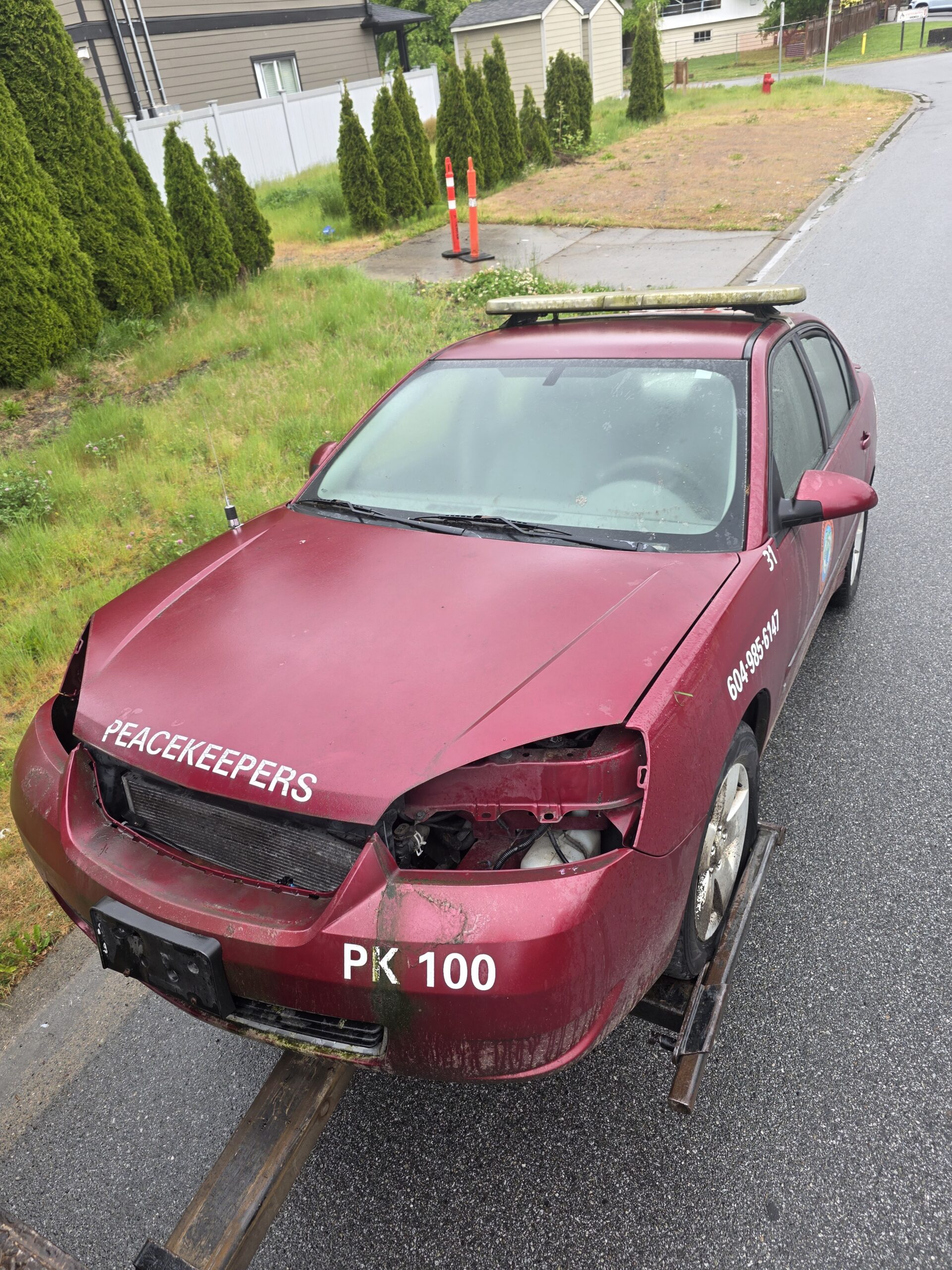 Damaged sedan on a flatbed tow truck after a rollover, cash offer for car service in Coquitlam