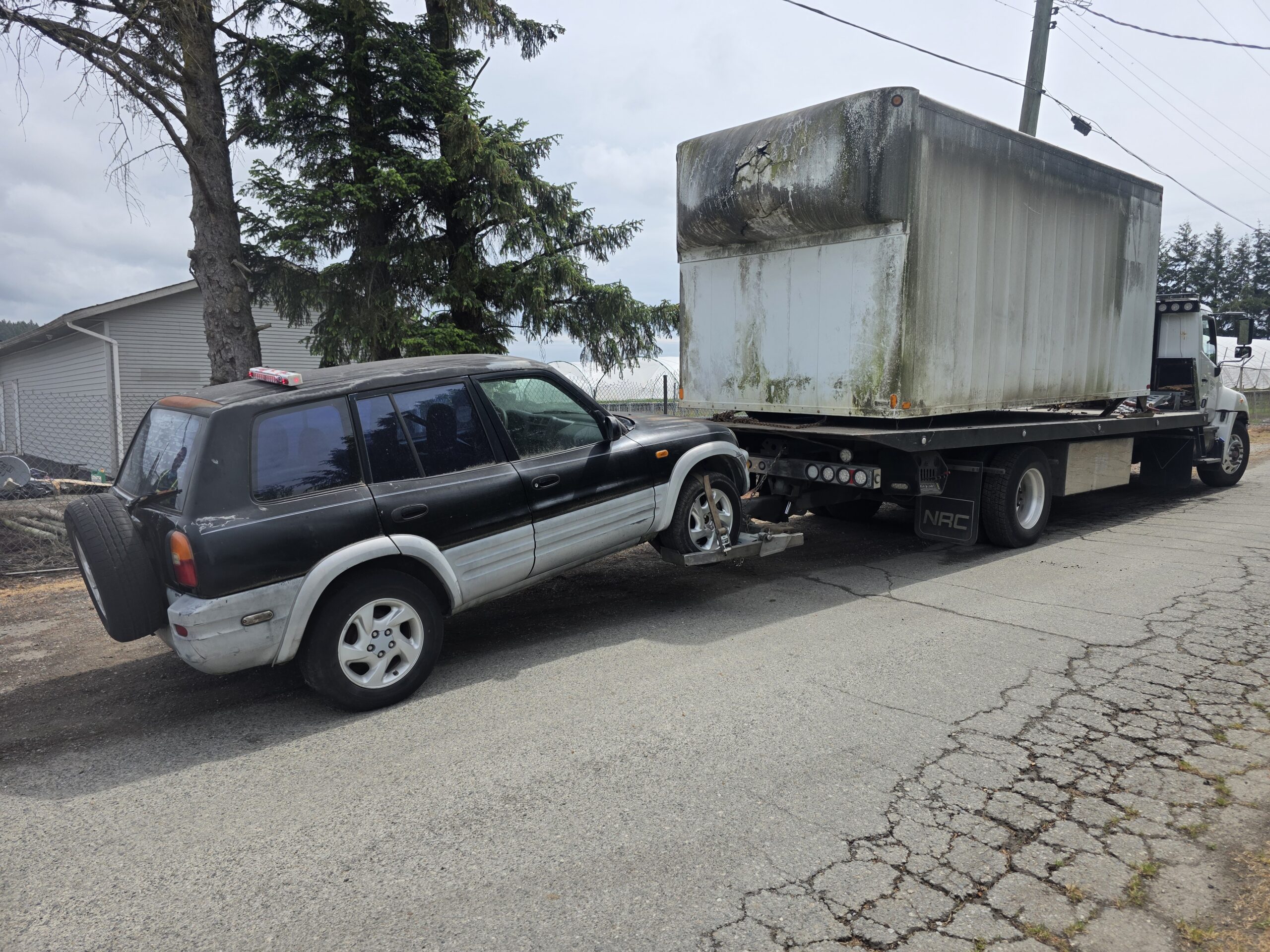 Hauling away an old industrial storage container during a pickup job